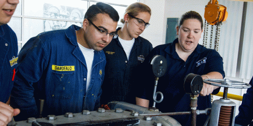 marine engineering students examine an engine
